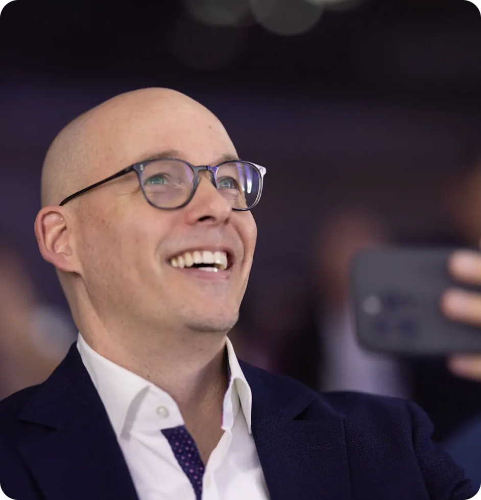 A man looking up while recording with his phone.