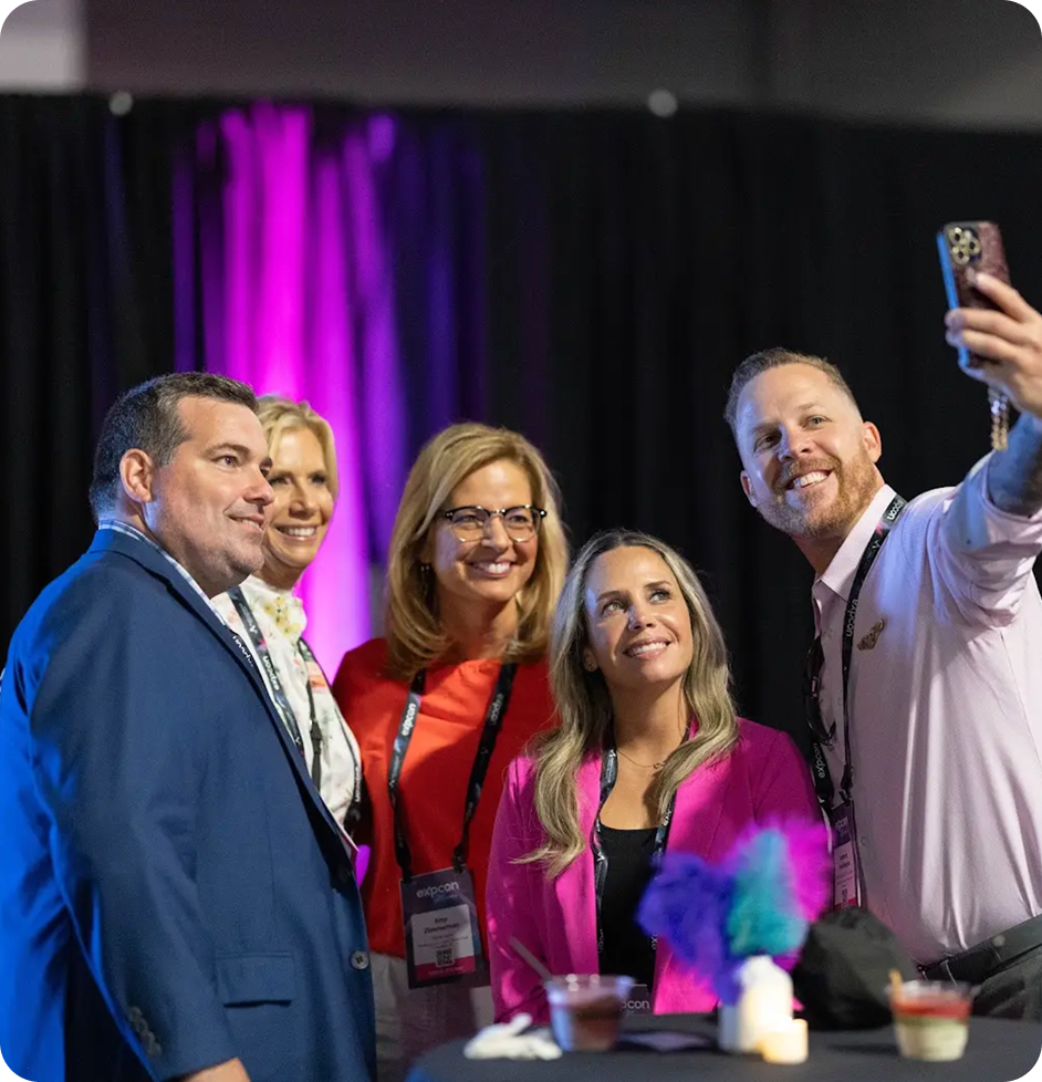 Five people smiling preparing to take a selfie.